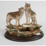 A resin figure of two wolves on a rock: