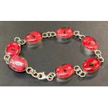 Silver bracelet with red stones: 10g total weight.