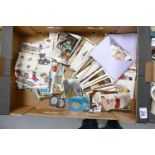 A mixed collection of items to include: vintage postcards, loose stamps, Commemorative napkins,