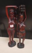 Two African hardwood hand carved figures: one lady carrying water, one lady carrying firewood,