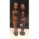 Two large African hardwood hand carved figures of tribal ladies: one grinding flour and one carrying