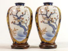 Pair of Oriental panelled vases with Prunus decoration: Height on stands 13.5cm (2)
