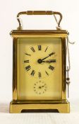 Oval brass cased carriage clock timepiece with alarm: Measures 14.5cm including handle. Winds,