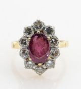 18ct gold ruby & diamond ring: Oval centre ruby surrounded by 10 diamonds, size J, 4.3g.