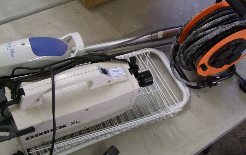 A mixed collection of items to include a steam mop, handheld vacuum cleaner, power cable etc.
