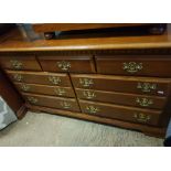 Reproduction mahogany veneered 7 drawer chest of drawers, 141cm in width.