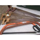 A collection of vintage wooden handled saws together with more modern examples.