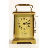 Oval brass cased carriage clock timepiece with alarm: Measures 14.5cm including handle. Winds,