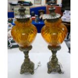 A large decorative pair of Lamps: with ornate brass bases and shaped orange glass shades, h81cm. (2)