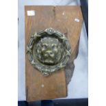 Large Brass Lions Face Door Knocker mounted on wooden plank