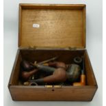 A collection of old smoking wood pipes in oak box: