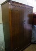 Oak double wardrobe on castors, 122cm W x 51cm D x 193cm H.