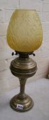 Brass oil lamp with yellow glass shade, no chimney.