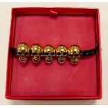 Butler & Wilson costume jewellery bracelet Five gold effect skulls on faux leather strap