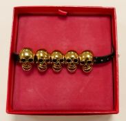 Butler & Wilson costume jewellery bracelet Five gold effect skulls on faux leather strap