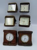 A collection of 6 Alligator skin covered travel clocks including 'Smiths' and 'Mappin' examples