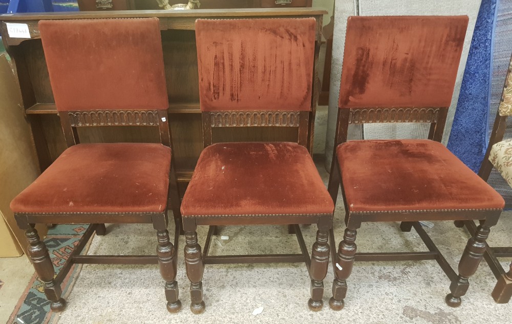 A group of three early 20th century dark oak chairs with red velvet upholstery and stretchered