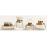 Four heavy glass crystal inkwells with brass fittings, tallest 9.5cm. (4)