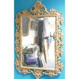 Large ornate gilt framed bevel edged wall mirror, height 138cm x width 89cm.