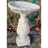 Stone garden ornament of a vineyard bird bath, adorned with vine leaves