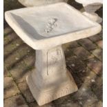 Stone garden ornament of a clasico bird bath. Square bird bath adorned with a rose