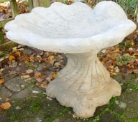 Stone garden ornament of a shell bird bath