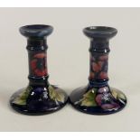 A pair of Moorcroft pansy candlesticks. Height 12cm. ( 1 candlestick several cracks which have