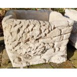 Stone garden ornament of a ivy brick planter, festooned with ivy