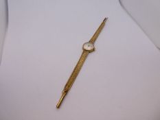 Vintage 9ct yellow gold ladies wristwatch, on 9ct gold strap, champagne face by 'Tissot', 15g approx