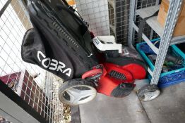 A Cobra cordless lawn mower, with battery charger