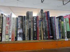 A shelf of military related books and similar