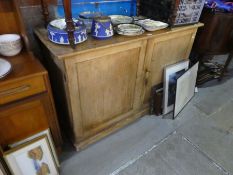 An old stripped pine two door cupboard