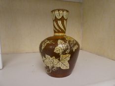 A pottery vase having decoration of ivy and figures, 17cm