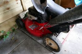 A Briggs & Stratton petrol lawn mower and hosepipe and reel