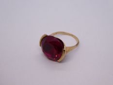 Unmarked yellow metal cocktail ring set with a large circular ruby stone, approx 1.5cm diameter, siz