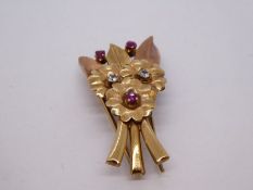 Antique yellow metal brooch clip in the form of a floral spray, the flower head set rubies and clear