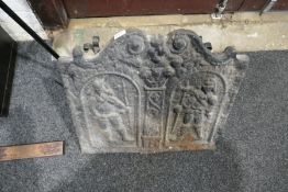 An iron fireback decorated two figures and a fire grate