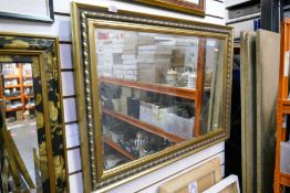 A gold framed bevelled edge mirror