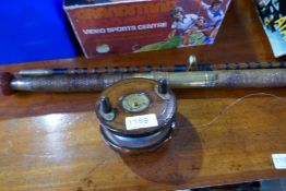 A vintage cane two piece fishing rod having wooden reel