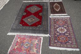 A modern Bokhara having two diamond medallions and three smaller rugs