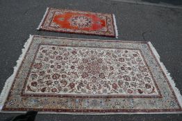 A Persian style rug having all over floral decoration with central spandal 228cm x 142cm and one oth