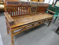 An old oriental bench possibly Chinese having carved arms and panels to back 170cm