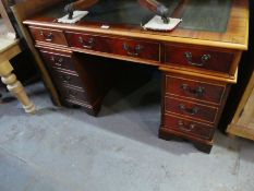 A reproduction twin pedestal desk having six drawers & cupboard