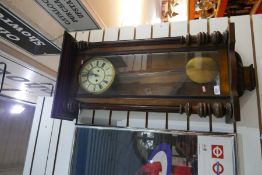 A wall hanging wood and glazed longcase pendulum clock with enamel dial