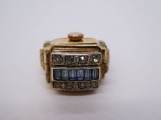 9ct yellow gold watch ring mounted with a Orex 17 Ruby watch concealed by a panel, set blue and whit