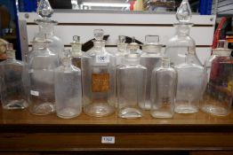 Two large clear glass chemists bottles of pear shape and quantity of other chemists bottles