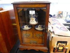 An early 20th Century oak tobacco cabinet having 3 drawers with glazed door