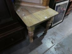 An old pine table on turned legs and a hanging corner cupboard