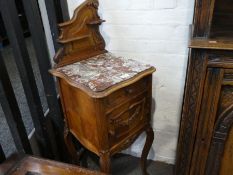 A French carved walnut bedside cupboard having marble top