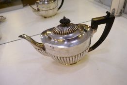 A silver gadrooned design Victorian teapot on oval base, with gadrooned spelt and knop, with black h